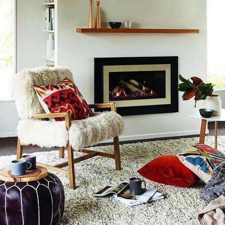 Gas fire in modern lounge, next to single chair and coffee table