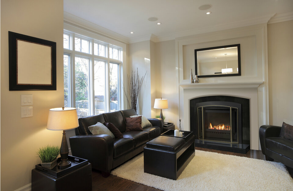 Gas fire in lounge, with dark leather couch, coffee table amd lamp