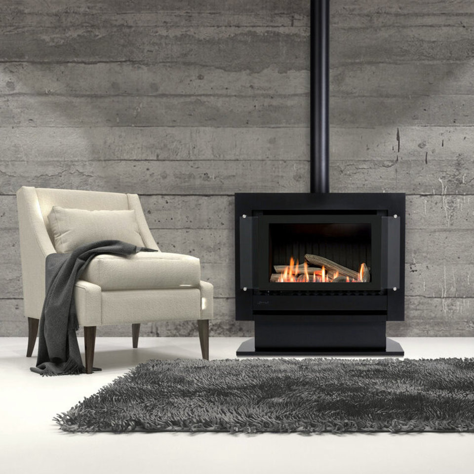 Freestanding gas fire in black next to styled armchair