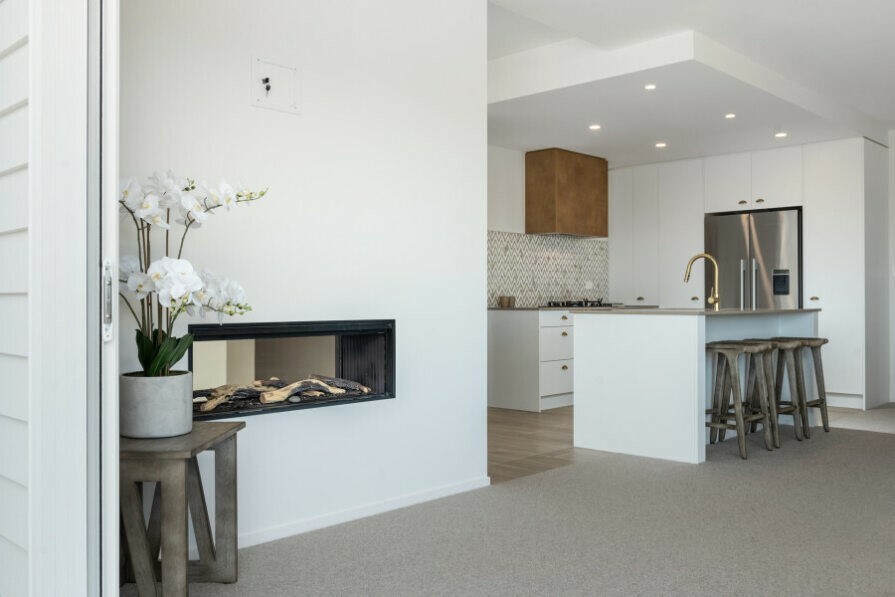 Gas fire in lounge with kitchen in the background