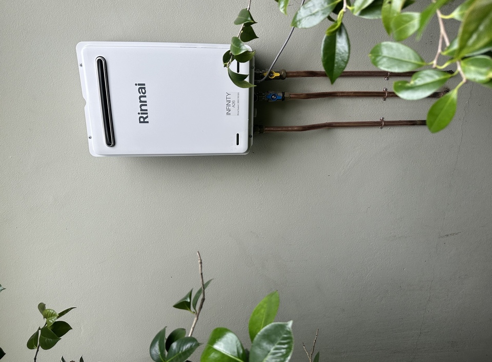 Rinnai gas hot water unit on house with plants to the side
