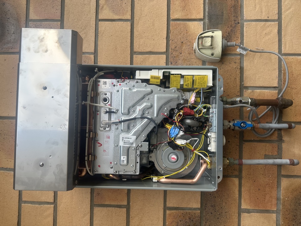 Gas hot water unit opened and being serviced