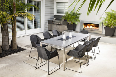 Outdoor gas fire next to table and chairs on paved patio